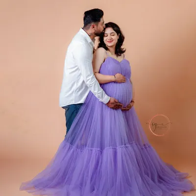 A tender moment between partners as they anticipate their new arrival. This pose, with him gently kissing her forehead, is a classic way to show love and support during a maternity photoshoot.