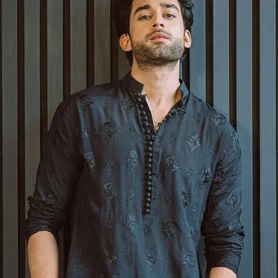 An example of our custom kurta sets. This is a black kurta with self-colored floral embroidery and a unique beaded placket, offering a simple yet stylish option for pujas, festivals, or pre-wedding functions.