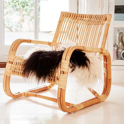 This is a classic low-slung lounge chair made from natural rattan. Its ergonomic design and sturdy, bent-cane frame make it a very comfortable and durable seating option.