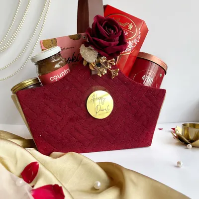 A rich, maroon quilted basket filled with luxury chocolates and gourmet jars. This hamper is designed to make a statement and is perfect for personal Diwali gifting.