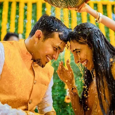A beautiful, happy moment during a Haldi ceremony. We capture the joy and connection between the couple as they are showered with blessings and turmeric.