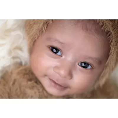 That first little smile is absolutely priceless. This close-up shot captures the bright eyes and sweet expression of an awake and happy baby, showing a glimpse of the wonderful personality that is just beginning to shine through.
