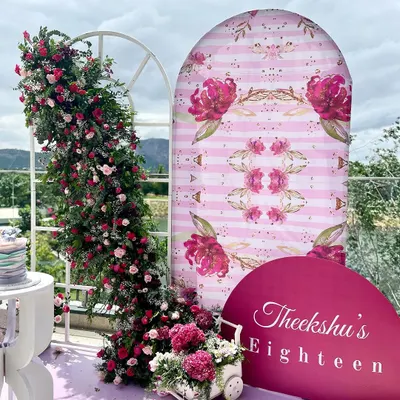 An absolutely dreamy 18th birthday setup on a balcony with a stunning view. We used a soft pink and magenta palette, a custom floral-print backdrop, and a lush, cascading flower arrangement to create a picture-perfect photo corner.