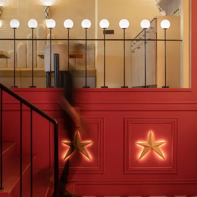 At Masala, New Delhi, the bold red staircase is accented with custom star-shaped wall lights. This detail adds a touch of whimsy and guides guests upward, setting a celebratory tone from the moment they enter.
