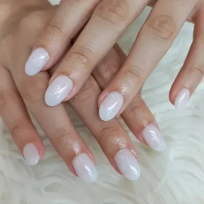 The perfect "your nails but better" look. This manicure features a sheer, milky white polish on beautifully shaped oval nails for a clean, healthy, and natural appearance.