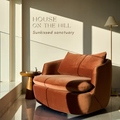 This plush, rust-toned armchair sitting in a sunlit corner is the epitome of the 'sunkissed sanctuary' we created. It's a perfect example of using statement furniture and natural light to design a space for peaceful moments.