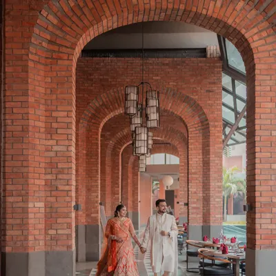 A stunning example of using architecture to create a powerful image. The couple walks hand-in-hand through a corridor of brick arches at Avadh Utopia, with the repeating patterns drawing the eye towards them.