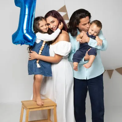 A beautiful family portrait celebrating a first birthday. The love and connection between parents, sister, and the birthday boy are what make this photo so special.