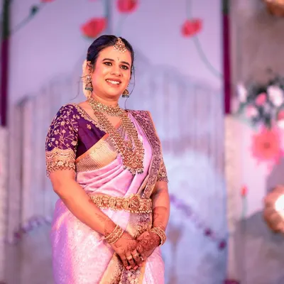 For her son's naming ceremony, I designed this rich purple blouse to contrast with her light lavender silk saree. The blouse is heavily embroidered with gold threadwork, creating a luxurious and celebratory look.