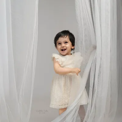 A burst of pure, spontaneous laughter from a toddler playing with sheer white curtains. My baby-led sessions are all about creating a space for joy to happen naturally.