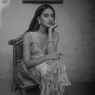 A seated portrait for a PhotoVogue feature, shot on film to achieve a timeless and classic look. The use of natural light and shadow creates depth and mood, ideal for editorial photography.