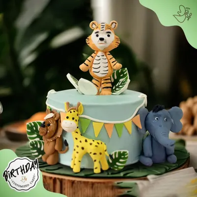 A delightful jungle-themed cake featuring a friendly tiger, giraffe, lion, and elephant. The cute, stylized animals make this a perfect choice for a young child's birthday.