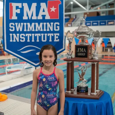 Celebrating a champion! FMA student Lisa proudly poses with her trophy after winning the 50m backstroke event with an incredible time of 32.1 seconds. We train our swimmers to win.