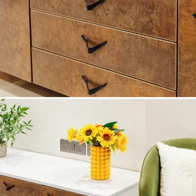 Details matter. This image shows the unique, wing-like black handles on rustic-finish drawers, contrasted with a bright yellow vase on a clean white countertop.