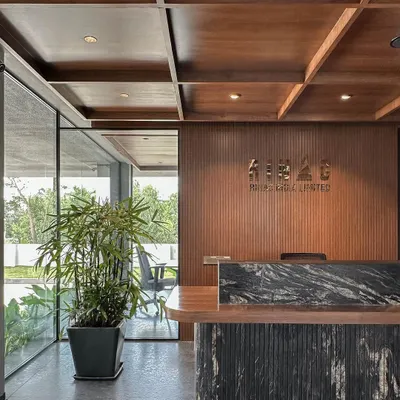 The main reception desk at RINAC HQ, featuring a custom black granite top and a coffered wood ceiling. This space immediately communicates a sense of quality and established professionalism.
