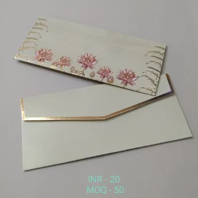 A shagun envelope depicting a serene garden scene with palace domes and lush trees against a sky-blue background. The gold foil accents highlight the architectural details.