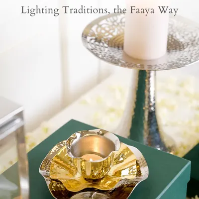 Some traditions never lose their glow. This image captures our lighting traditions the Faaya way, with a hammered gold diya plate and a tall, elegant silver candle stand. These pieces are made to honor rituals and elevate your celebrations.