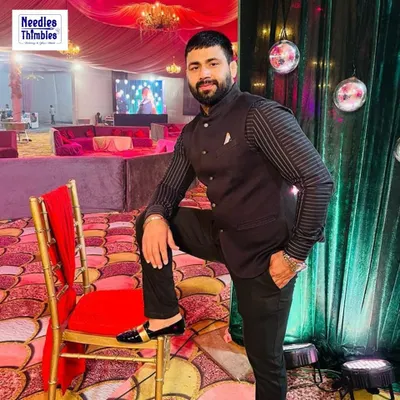 Our client looking sharp at a wedding reception in a custom-made black Bandhgala suit. The striped detailing on the sleeves adds a modern touch to the classic silhouette, making it a versatile choice for any formal celebration.