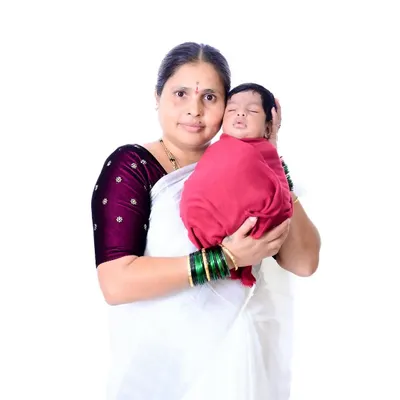 A grandmother's gentle embrace. This portrait captures the pride and unconditional love in her expression as she holds her newborn grandchild, a beautiful moment of connection.