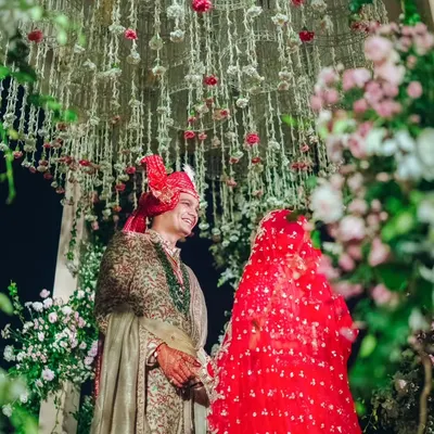 A romantic portrait of the couple under a canopy of cascading jasmine and rose buds. This intricate floral work inside the mandap created a dreamy and fragrant setting for their vows.
