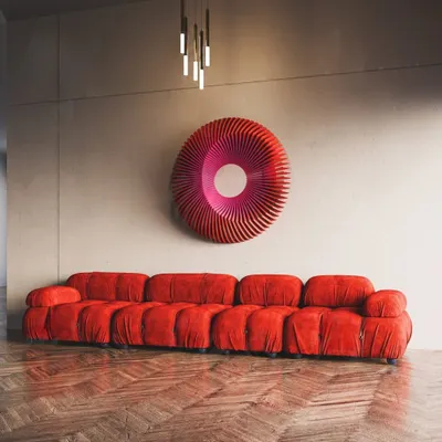 Our 'Art No.11' Radiant Circles sculpture in a dramatic red, paired with a matching sofa. The piece's wavy, circular form creates a stunning optical effect.
