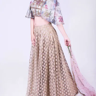 Blessed to create such memorable outfits. This ensemble features a floral organza cape crop top with detailed embroidery and a gold brocade skirt. The sheer cape adds a touch of modern drama to the traditional lehenga silhouette.