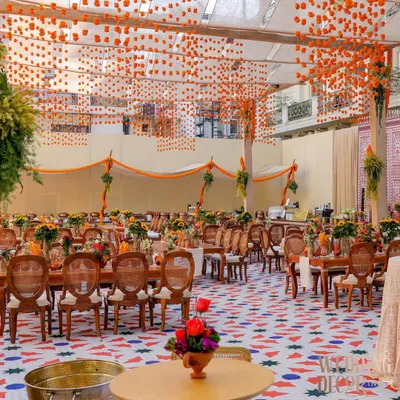 A wide view of the 'Old Delhi' themed brunch, showing the custom flooring, tenting with marigold garlands, and long community-style dining tables. The entire space was designed to feel like an open-air courtyard in a traditional haveli.