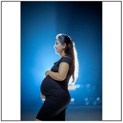 A dramatic night portrait using a single light source to create a stunning silhouette of the mom-to-be. This artistic style is perfect for a unique and memorable photo.