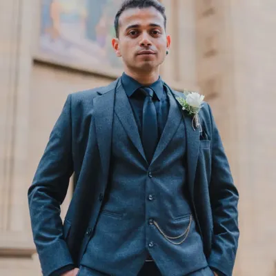 A sharp and stylish portrait of the groom in his three-piece suit, looking confident and ready for his wedding day.