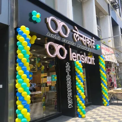 A grand opening decoration for a Lenskart store in Panvel. The blue, yellow, and green spiral balloon pillars are designed to be vibrant and welcoming to new customers.