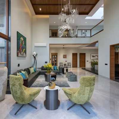 This double-height living room is all about scale and light. The massive windows flood the space with natural light, while the custom art-piece chandelier adds a touch of modern sculpture.