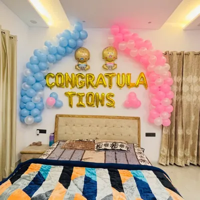 A sweet 'Congratulations' setup for welcoming twins. I used pink and blue balloon arches over the bed with baby-themed foil balloons.