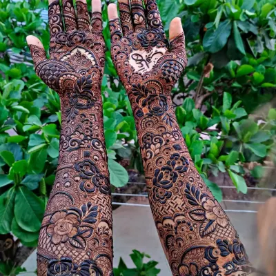 A full bridal design with beautiful, bold floral work and a heart holding the couple's initials. I love how the dark and light shades create so much depth in this intricate henna pattern.