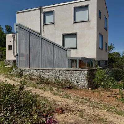The 'Wildgrass' home in Coonoor, showing an addition with a perforated metal screen. We believe a home can grow like a city, and this project was a chance to intimately re-engage with the original structure and the settling landscape.