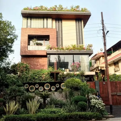 This modern home in Noida features a complete landscaping solution I designed and implemented. The project includes rooftop gardens, balcony planters, and extensive ground-level greenery with sculpted shrubs and trees for a cohesive, nature-filled property.