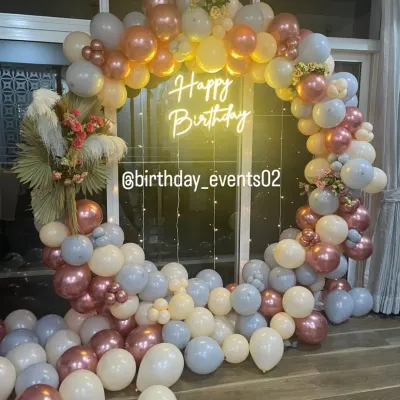 A full view of our elegant ring backdrop, featuring a mix of pastel blue, cream, and rose gold metallic balloons. This setup includes dried palm leaf accents and fairy lights for a soft, bohemian touch.