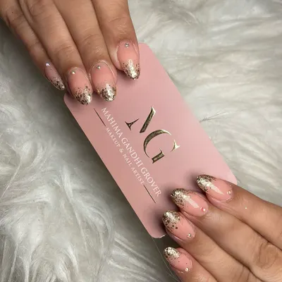 A close up of sparkling elegance. These almond shaped nails feature a beautiful glitter ombre effect with delicate stonework, a popular and glamorous choice for festive occasions.