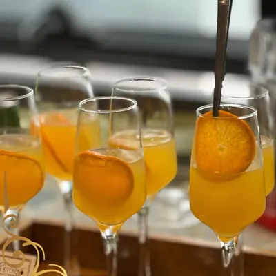 A refreshing orange spritz, garnished with a fresh orange slice. A simple, elegant, and delicious welcome drink for any event.