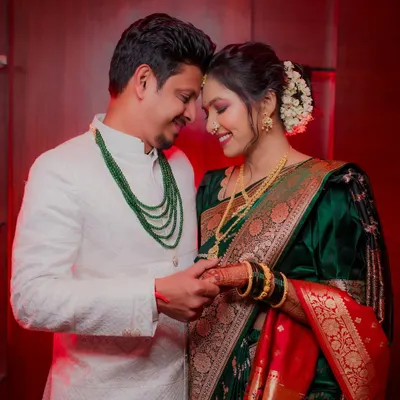 An intimate engagement portrait. The couple holds hands, their foreheads touching, in a moment of quiet connection. The warm, dramatic lighting adds to the romantic feel of the photograph.