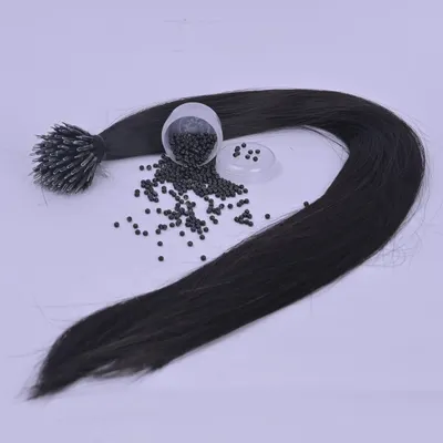 This image shows a bundle of I-tip hair extensions along with the nano beads used to attach them. These tiny beads ensure a discreet and comfortable application for long-lasting volume.
