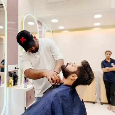 A client relaxes while our expert stylist provides a detailed beard trim. We create a comfortable and professional environment for all our men's grooming services.