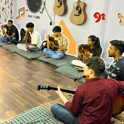 Our after-school guitar class in session. Students sit in a circle, learning from our instructor and each other. This collaborative environment is key to building both skills and friendships.