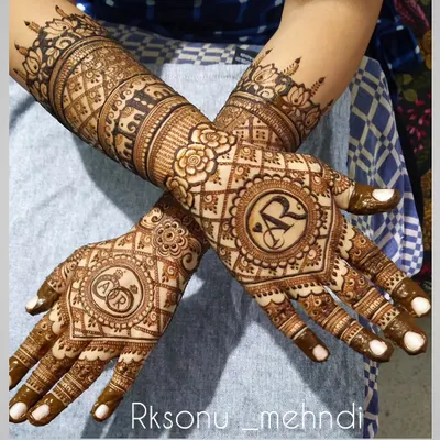 A lovely design for a ring ceremony, featuring the couple's initials inside a decorative mandala. The pattern is intricate but focused on the center of the palm, leaving space for a light and elegant feel.