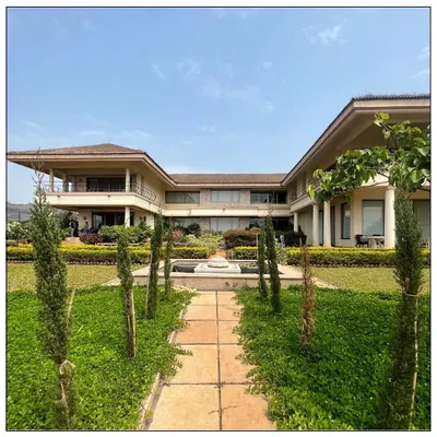 Planned on an open H design, this Tuscan architecture inspired home is set on the edge of Kune Plateau. It features a 100 foot-long corridor, expansive lawns, and a central water feature, capturing the essence of a grand Italian villa.