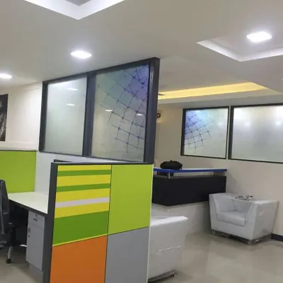 Interior works for Tertium Technology in RT Nagar, showing a modern office layout with low-height cubicles in green and grey. The design includes frosted glass partitions and well-lit workspaces to foster a collaborative environment.