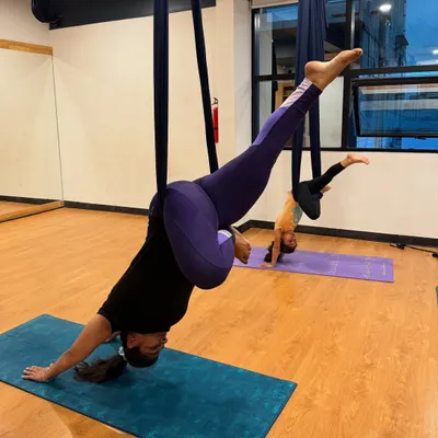 A mother and daughter duo exploring inverted poses in our family aerial yoga class. It's a wonderful way to build trust and share a unique experience.