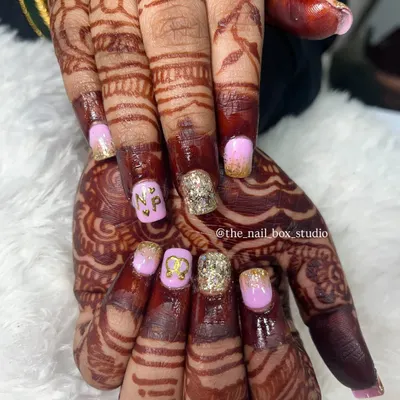 A close up of this personalized engagement nail art. I carefully hand-painted the couple's initials 'N' and 'P' in gold on a soft pink base, paired with a sparkling gold glitter accent nail to match the bride's jewelry.