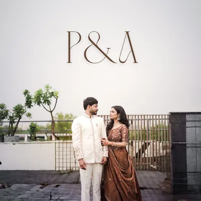 Piyush and Anjali stand together under their custom monogram at the Lemon Tree Hotel in Agra. This shot showcases a personalized detail of their engagement event.