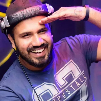 A classic DJ pose, smiling from behind the decks with my Technics headphones. This is my happy place, where I connect with the music and the crowd.