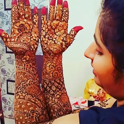 A bride admiring her full-arm mehndi. I love this moment, when the intricate patterns come together to create something truly special for her big day.